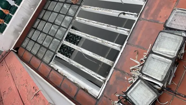 Close-up of glass panel edge and stainless steel bracket mounting