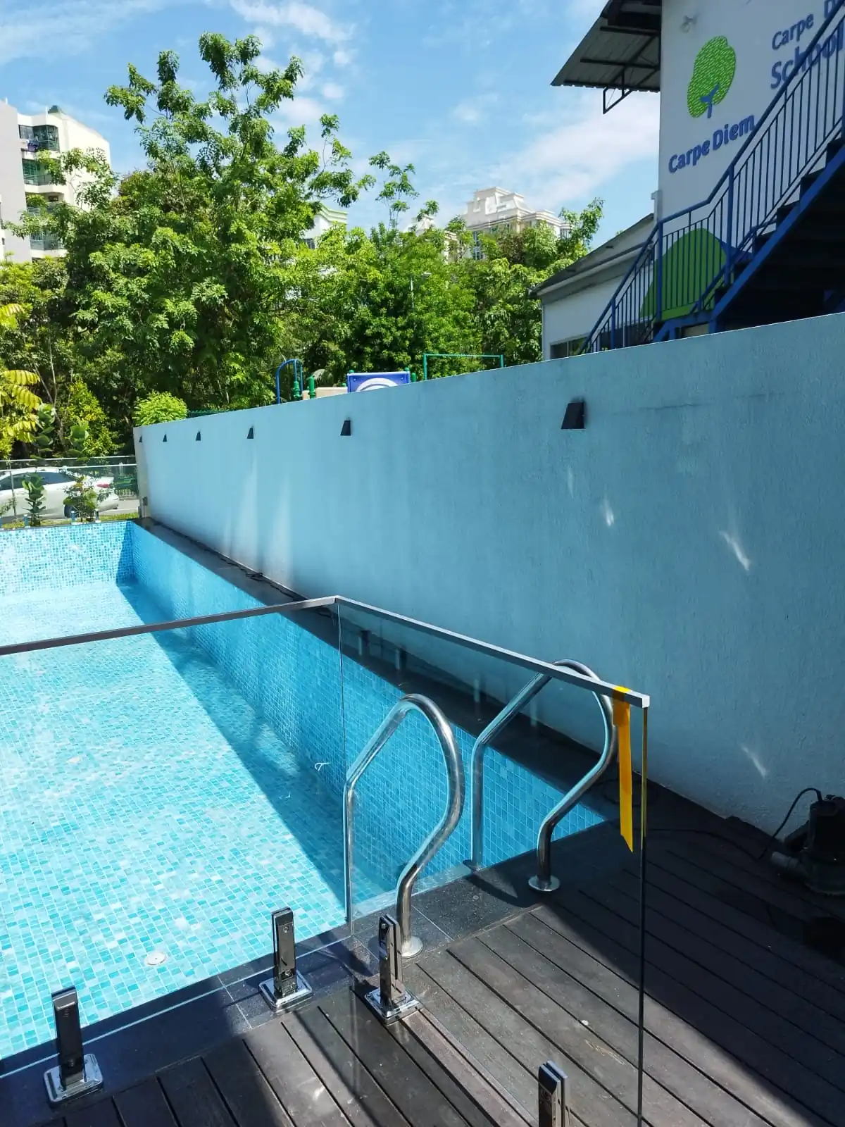 Frameless glass pool barrier with stainless steel spigot supports