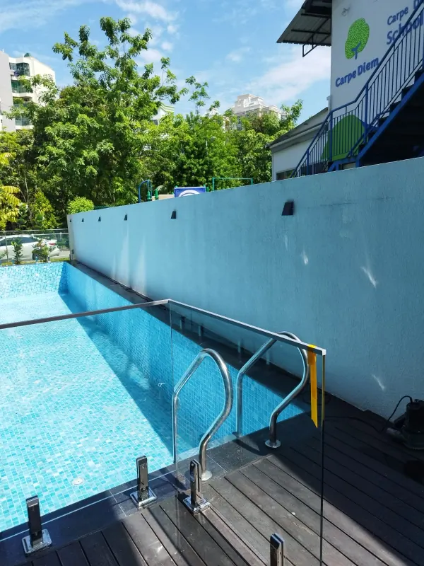 Frameless glass pool barrier with stainless steel spigot supports