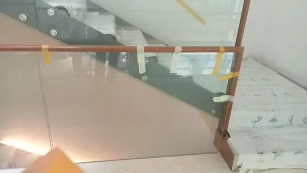 Wide angle view of glass railing with wooden handrail along staircase landing in Bukit Timah bungalow
