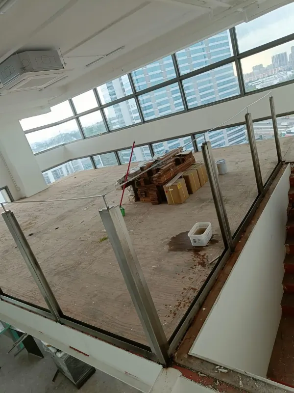 Wide angle view of completed glass and wood handrail along stair landing